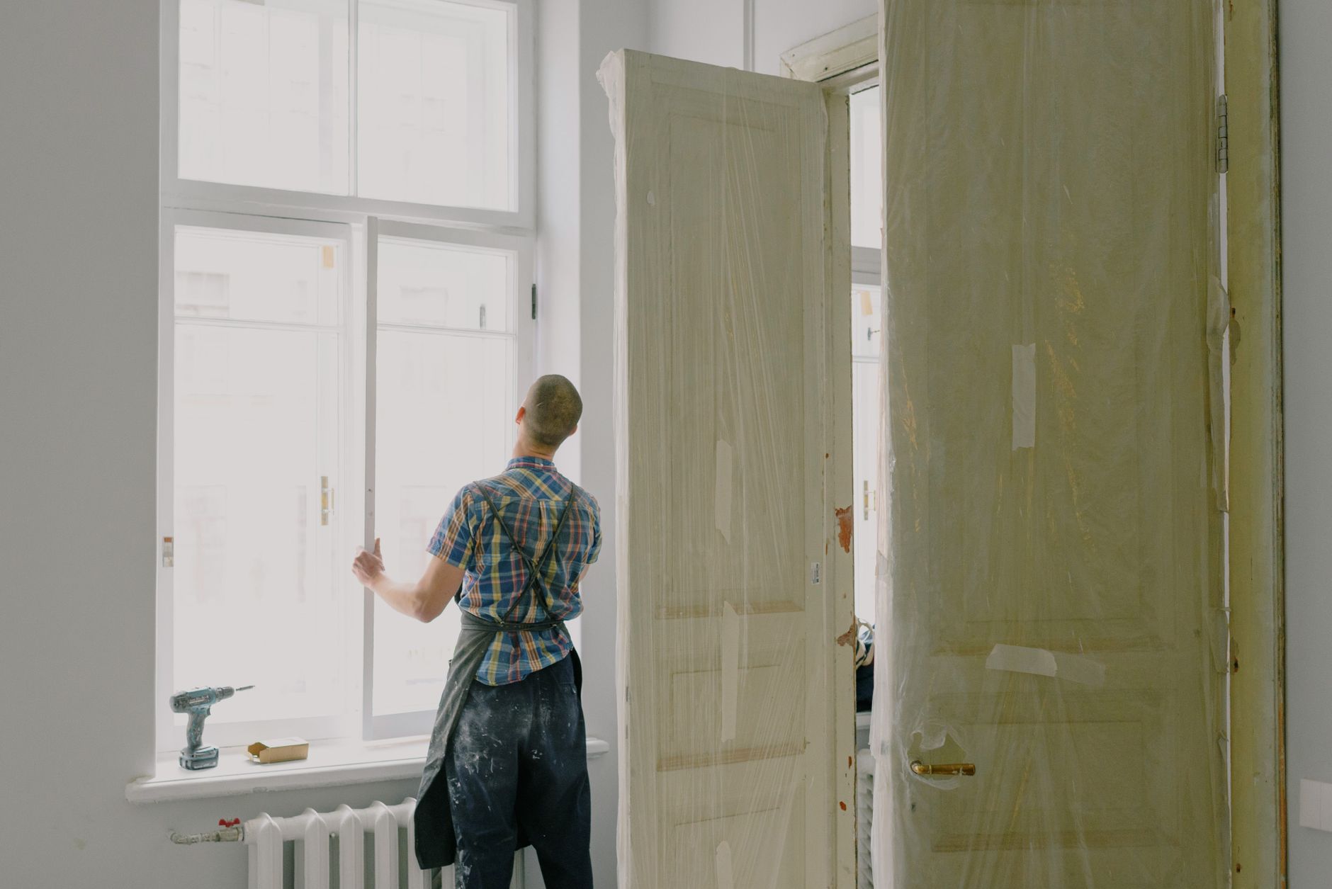 A handyman tightening a fitting in a bright home